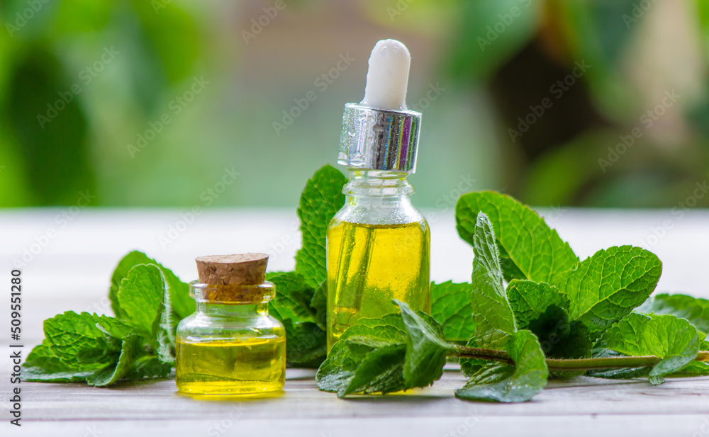 Peppermint essential oil in a small bottle. Selective focus. Peppermint essential oil in a small bottle. Selective focus.