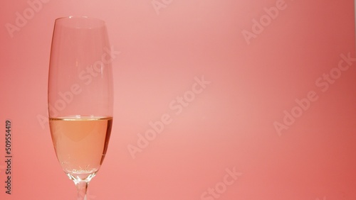 Champagne glass against pink background with copy space for title