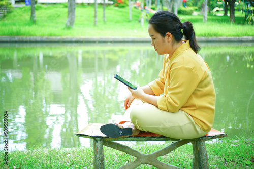 background image of a young woman sitting and relaxing in an outdoor park