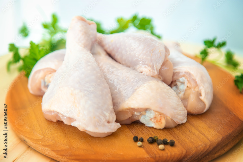 Raw meat chicken drumsticks on a board. Selective focus. Raw meat chicken drumsticks on a board. Selective focus.