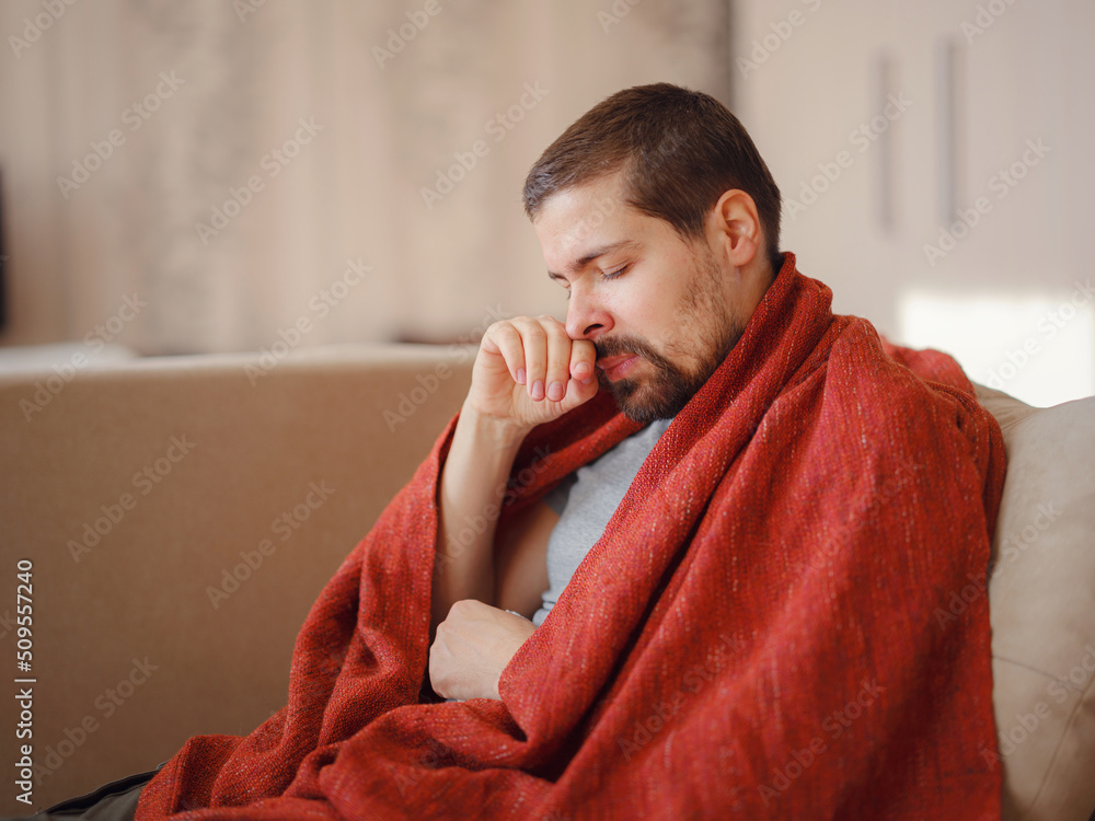 Coronavirus. Sick man of corona virus lying down in sofa and recovery from illness in home. Blowing his nose. The concept of high temperatures. The person is seriously ill. Coronavirus. Sick man of corona virus lying down in sofa and recovery from illness in home. Blowing his nose. The concept of high temperatures. The person is seriously ill.