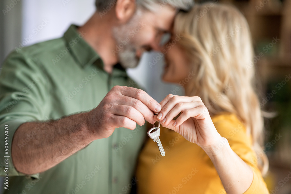 Closeup Shot Of Romantic Middle Aged Couple Holding Home Keys In Hands