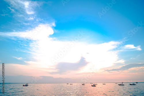 Beautiful sunrise on sea background with tropical wooden fishing boat