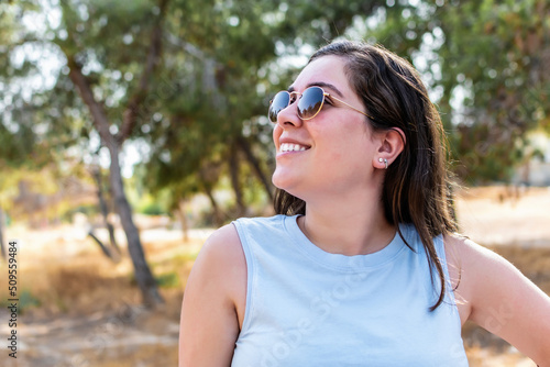 Side view portrait of an caucasian woman smiling in a forest.