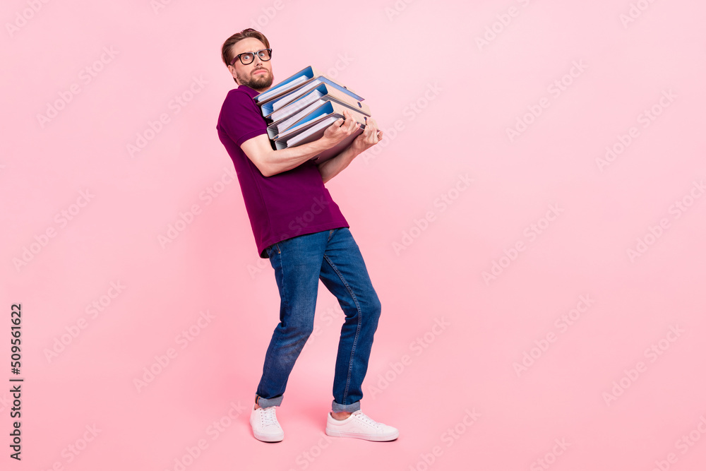 Full size profile side photo of young man hold folder agent project stack isolated over pink color background Full size profile side photo of young man hold folder agent project stack isolated over pink color background