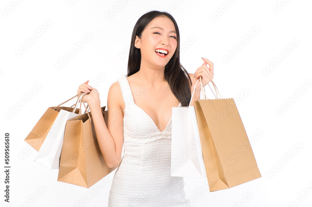 Portrait of young beautiful sexy asian female happy wearing a white dress holding shopping bags on white background. Portrait of young beautiful sexy asian female happy wearing a white dress holding shopping bags on white background.