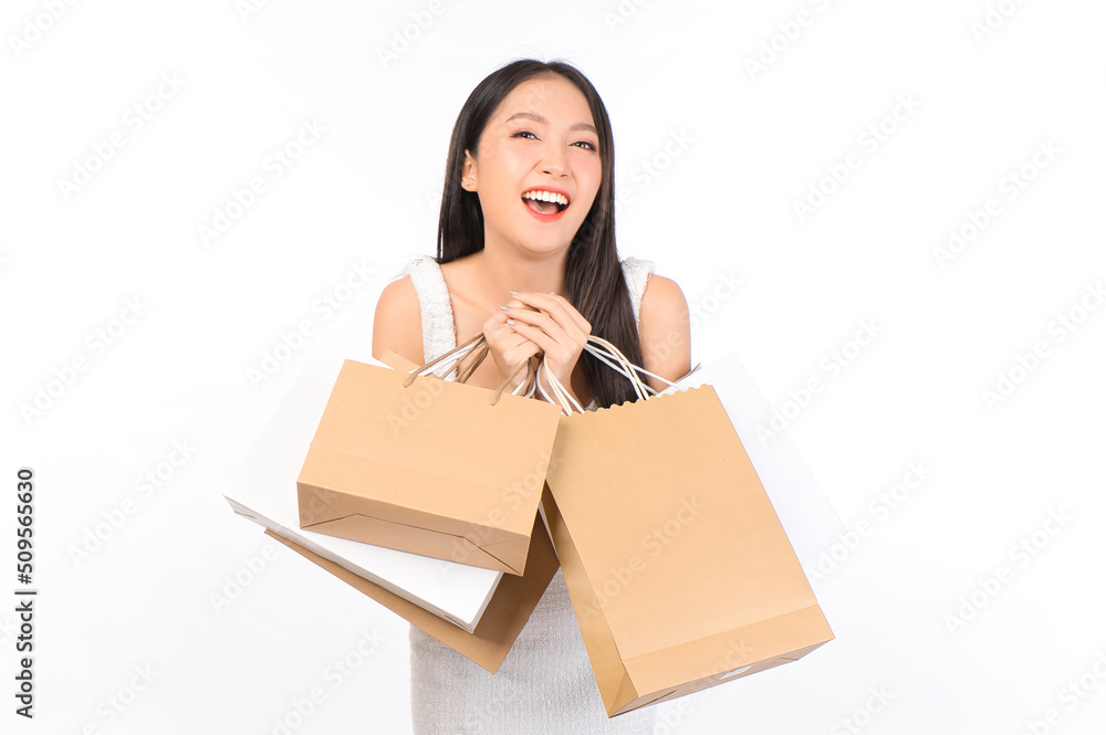 Portrait of young beautiful sexy asian female happy wearing a white dress holding shopping bags on white background. Portrait of young beautiful sexy asian female happy wearing a white dress holding shopping bags on white background.