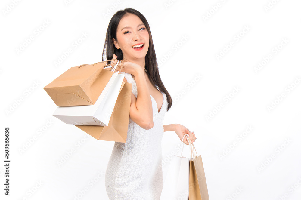 Portrait of young beautiful sexy asian female happy wearing a white dress holding shopping bags on white background. Portrait of young beautiful sexy asian female happy wearing a white dress holding shopping bags on white background.