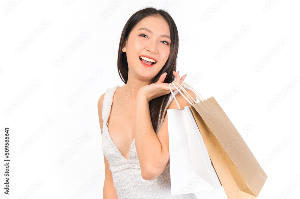Portrait of young beautiful sexy asian female happy wearing a white dress holding shopping bags on white background. Portrait of young beautiful sexy asian female happy wearing a white dress holding shopping bags on white background.