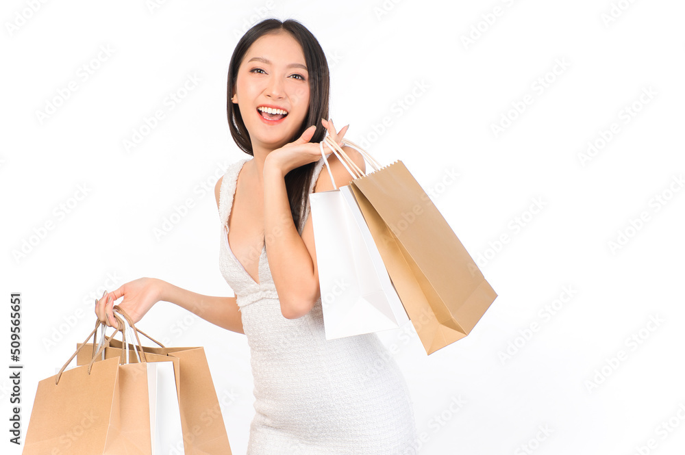 Portrait of young beautiful sexy asian female happy wearing a white dress holding shopping bags on white background. Portrait of young beautiful sexy asian female happy wearing a white dress holding shopping bags on white background.