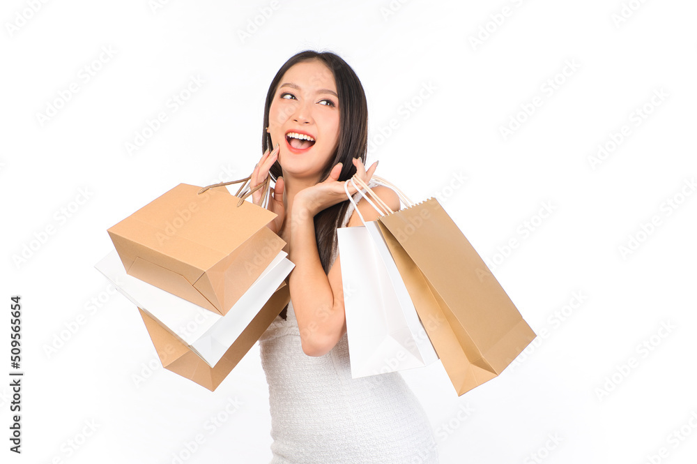 Portrait of young beautiful sexy asian female happy wearing a white dress holding shopping bags on white background. Portrait of young beautiful sexy asian female happy wearing a white dress holding shopping bags on white background.