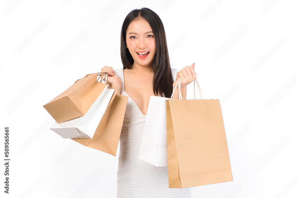 Portrait of young beautiful sexy asian female happy wearing a white dress holding shopping bags on white background. Portrait of young beautiful sexy asian female happy wearing a white dress holding shopping bags on white background.