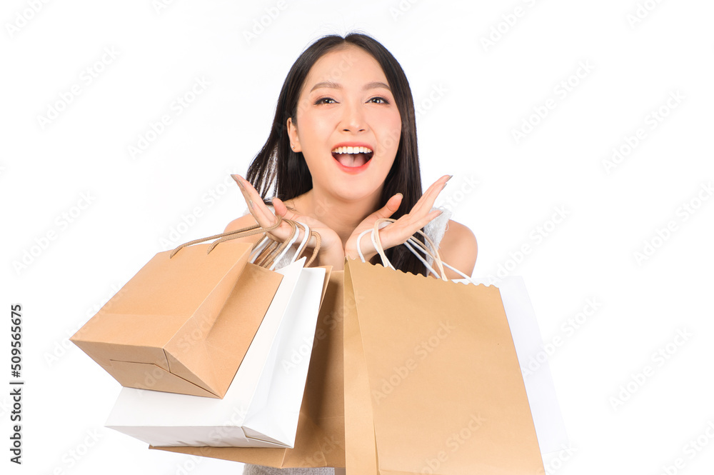 Portrait of young beautiful sexy asian female happy wearing a white dress holding shopping bags on white background. Portrait of young beautiful sexy asian female happy wearing a white dress holding shopping bags on white background.
