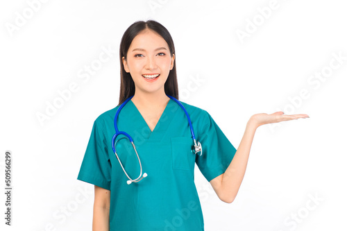 Portrait of professional confident young asian female smiling doctor in green scrubs showing presenting finger to empty space, doctor healthcare and doctors concept.