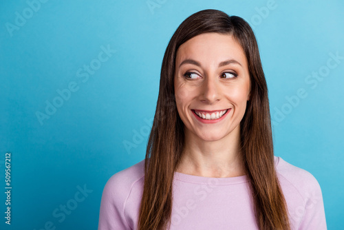 Photo of young cheerful lovely woman wonder look empty space idea isolated over blue color background