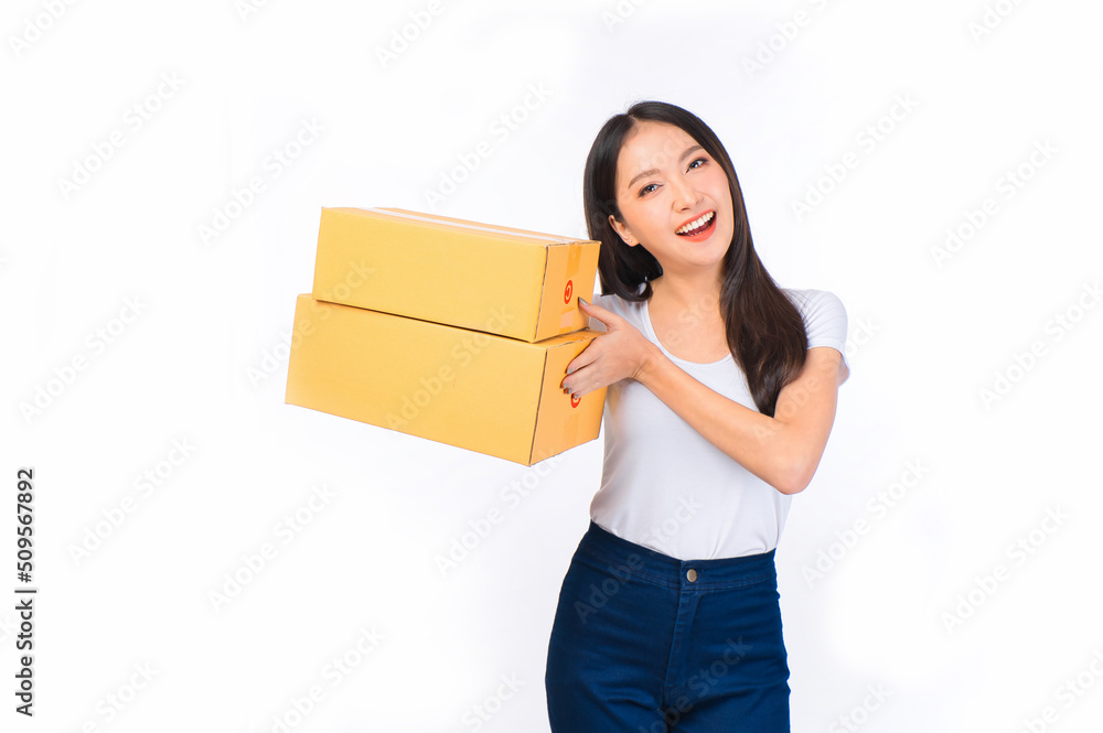 Happy cute asian woman smiling and holding package online marketing and delivery Start a small business at home on white background, Delivery shipping service concept. Happy cute asian woman smiling and holding package online marketing and delivery Start a small business at home on white background, Delivery shipping service concept.