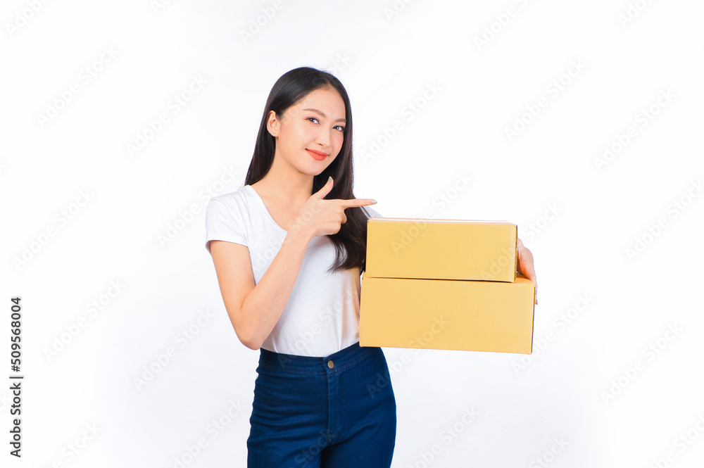 Happy cute asian woman smiling and holding package online marketing and delivery Start a small business at home on white background, Delivery shipping service concept. Happy cute asian woman smiling and holding package online marketing and delivery Start a small business at home on white background, Delivery shipping service concept.