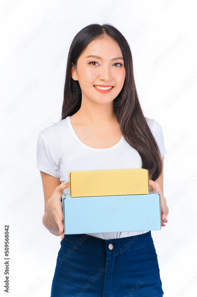 Happy cute asian woman smiling and holding package online marketing and delivery Start a small business at home on white background, Delivery shipping service concept. Happy cute asian woman smiling and holding package online marketing and delivery Start a small business at home on white background, Delivery shipping service concept.