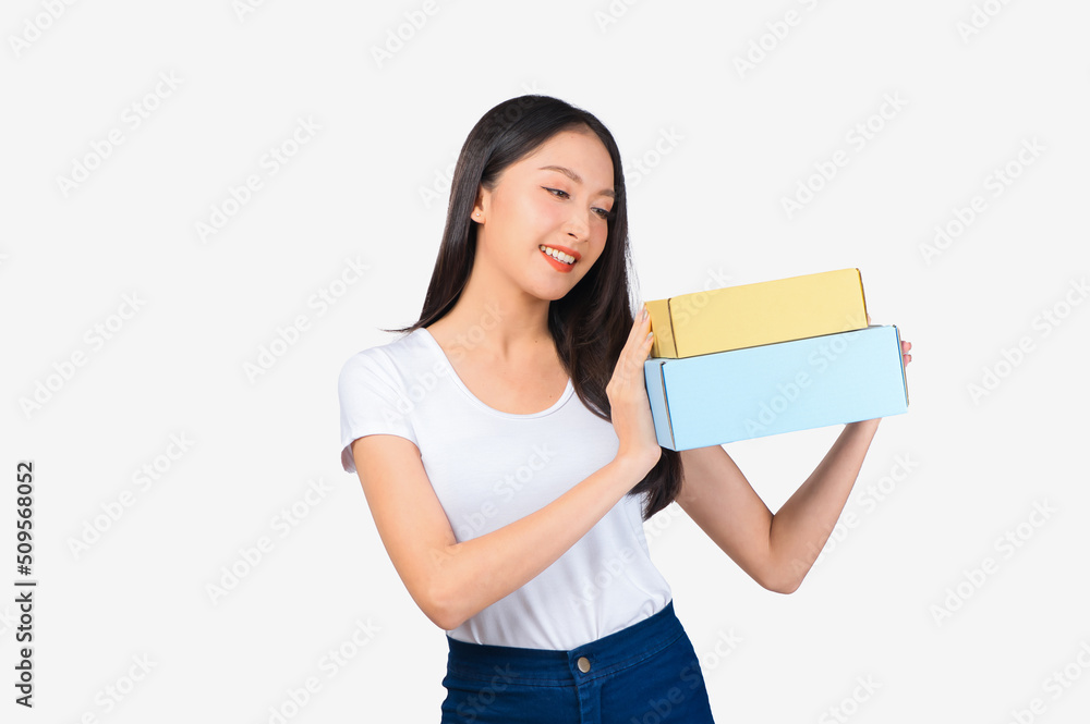Happy cute asian woman smiling and holding package online marketing and delivery Start a small business at home on white background, Delivery shipping service concept. Happy cute asian woman smiling and holding package online marketing and delivery Start a small business at home on white background, Delivery shipping service concept.