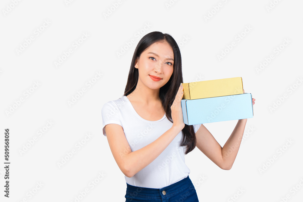 Happy cute asian woman smiling and holding package online marketing and delivery Start a small business at home on white background, Delivery shipping service concept. Happy cute asian woman smiling and holding package online marketing and delivery Start a small business at home on white background, Delivery shipping service concept.