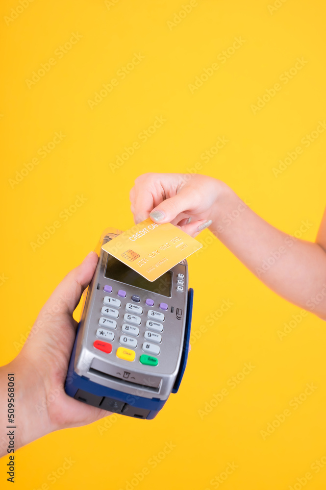 Moment of payment, payment with a credit card through terminal money yellow background,Mobile banking, online shopping Payment by card with the payment terminal. Moment of payment, payment with a credit card through terminal money yellow background,Mobile banking, online shopping Payment by card with the payment terminal.