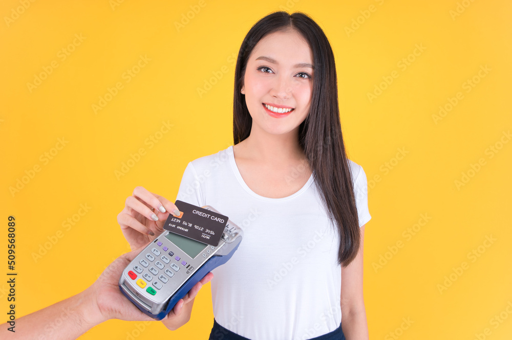 Moment of payment, payment with a credit card through terminal money yellow background,Mobile banking, online shopping Payment by card with the payment terminal. Moment of payment, payment with a credit card through terminal money yellow background,Mobile banking, online shopping Payment by card with the payment terminal.