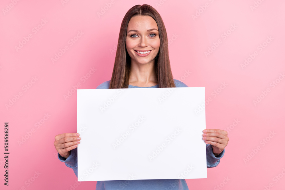Portrait of attractive cheerful girl holding in hands copy blank space banner ad isolated over pink pastel color background Portrait of attractive cheerful girl holding in hands copy blank space banner ad isolated over pink pastel color background