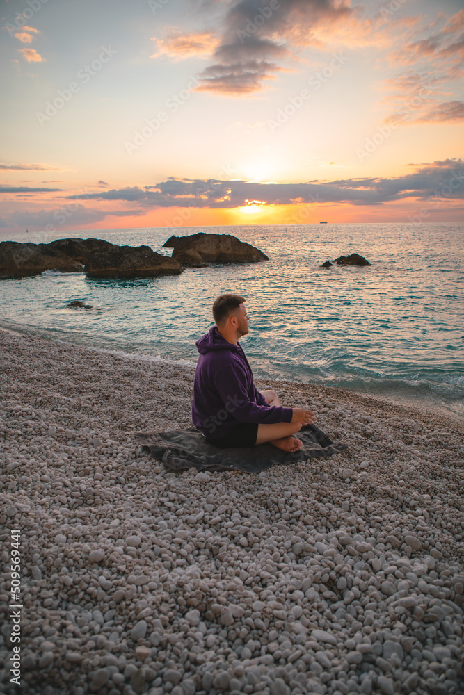man sitting at the sea beach enjoying sunset greece vacation