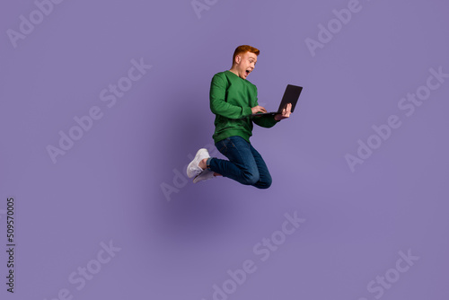 Full body profile side photo of young man jump up use laptop project isolated over violet color background