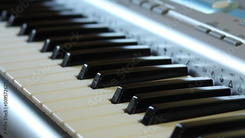A woman's hand wipes the keyboard of a musical instrument with a rag, taking care of musical equipment
