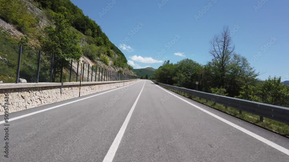 Moving view (car, motorbike or bicycle) of a mountain landscape during the spring season Moving view (car, motorbike or bicycle) of a mountain landscape during the spring season