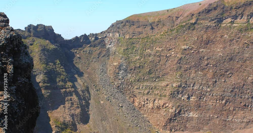 Panning across the huge crater and cliff of the Mount Vesuvius volcano in Pompeii, Italy. Panning across the huge crater and cliff of the Mount Vesuvius volcano in Pompeii, Italy.