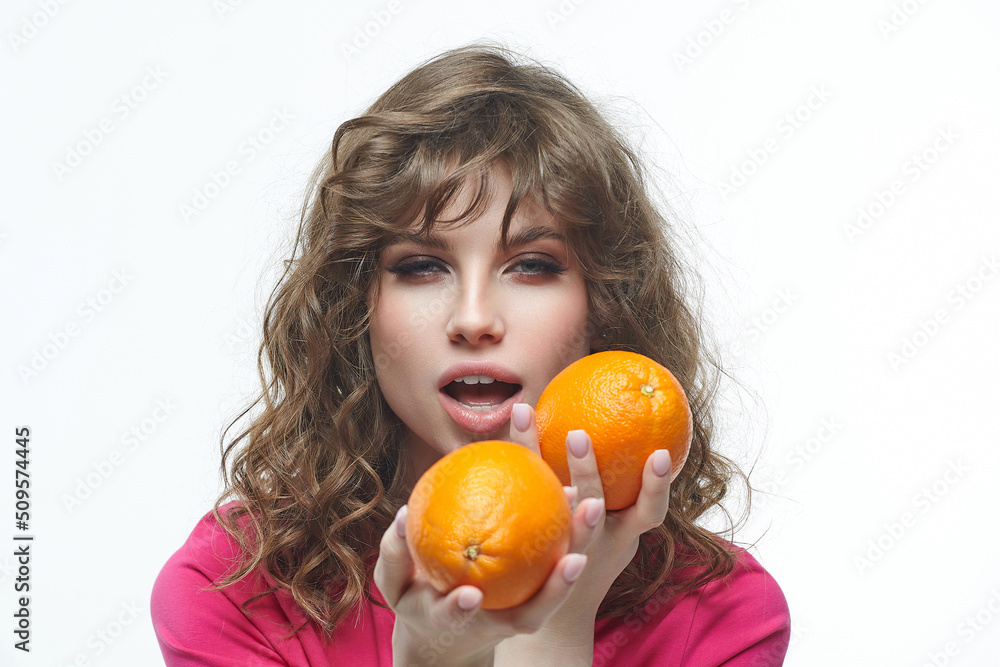 attractive girl seductively holds oranges in her hands photo shoot in the studio on a white background attractive girl seductively holds oranges in her hands photo shoot in the studio on a white background