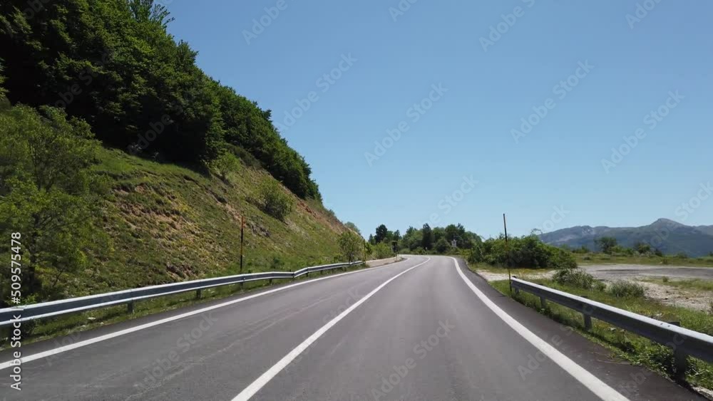 Moving view (car, motorbike or bicycle) of a mountain landscape during the spring season Moving view (car, motorbike or bicycle) of a mountain landscape during the spring season