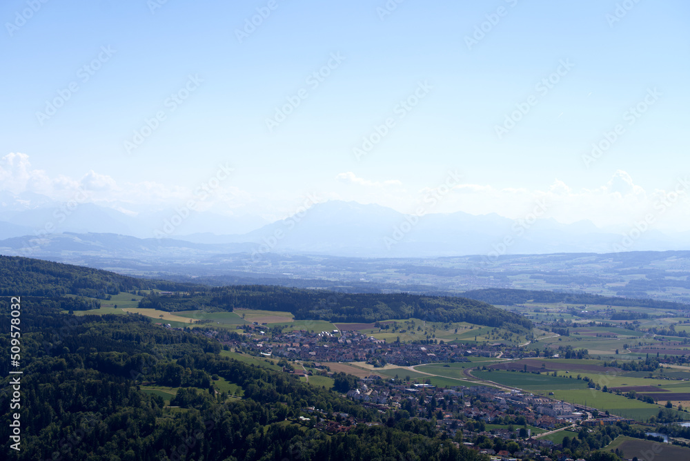 Aerial view of landscape at Canton Zürich with the Swiss Alps and Mount Pilatus in the background on a sunny spring day. Photo taken May 18th, 2022, Zurich, Switzerland.