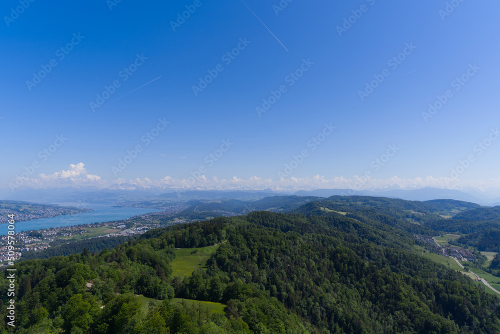 Naklejka premium Aerial view of Lake Zürich and Canton Zürich with the Swiss Alps in the background seen from local mountain Uetliberg on a sunny spring day. Photo taken May 18th, 2022, Zurich, Switzerland.