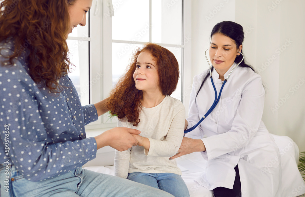 Female doctor puts stethoscope to child's back and listens to breathing and lungs of little girl who came for medical examination with her mother. Concept of health care and pediatric medical exam. Female doctor puts stethoscope to child's back and listens to breathing and lungs of little girl who came for medical examination with her mother. Concept of health care and pediatric medical exam.