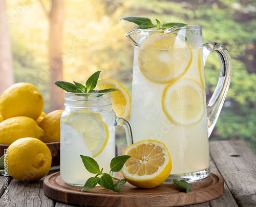 Fototapeta Glass and pitcher of lemonade with summer background