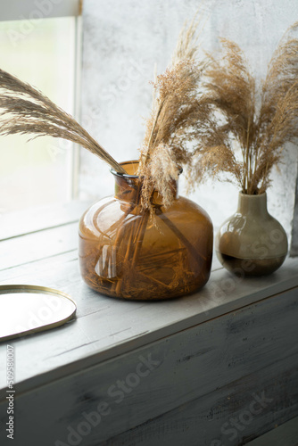 two glass vases are on the windowsill