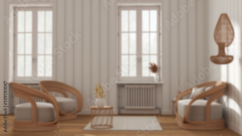 Blurred background  classic wooden living room  rattan sofa and armchairs  side tables and carpet. Windows  striped wallpaper  parquet and carpet. Modern interior design