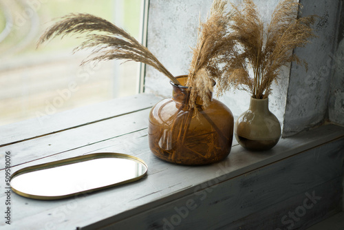two glass vases are on the windowsill