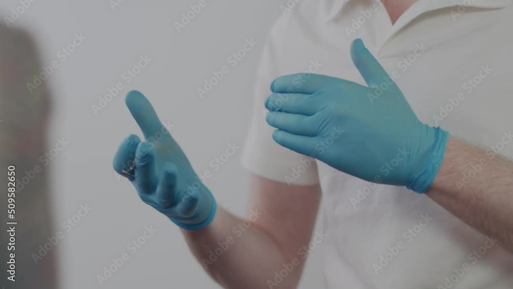 Dentist's hands in medical gloves close up. The dentist explains to the patient the treatment plan at the dental clinic. The work of a dentist. Healthcare and medicine concept Dentist's hands in medical gloves close up. The dentist explains to the patient the treatment plan at the dental clinic. The work of a dentist. Healthcare and medicine concept