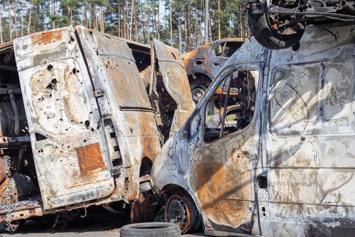 Cars after the fire. Iron parts of a burnt car. Burnt-out cars abandoned on the side of a quiet countryside. Explosion, the result of a fire. Car insurance concept. War of Russia against Ukraine.
