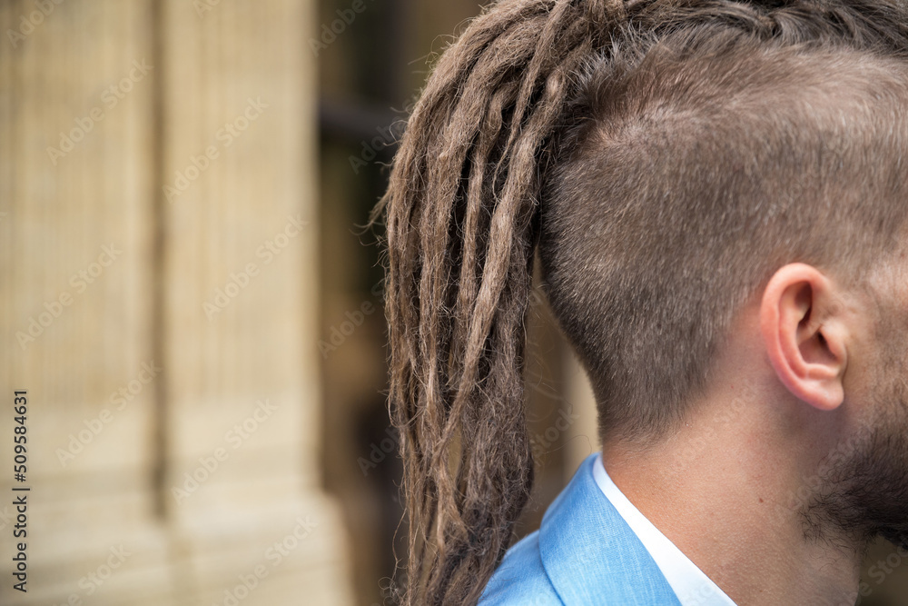 Fototapeta premium Close-up on hipster hairstyle with dreadlocks outdoors.