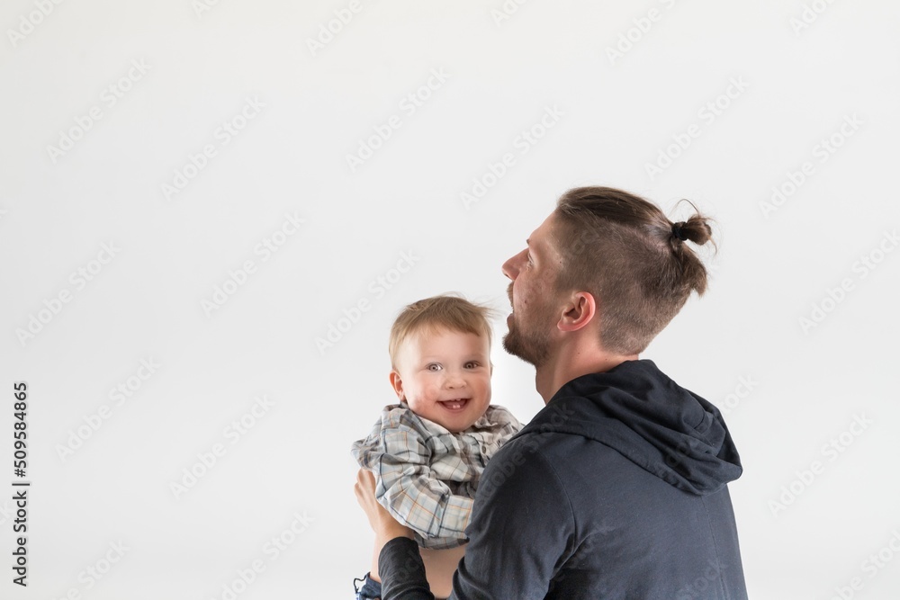 Joyful one year old kid is happy to spend time with his father, copy space on white background.
