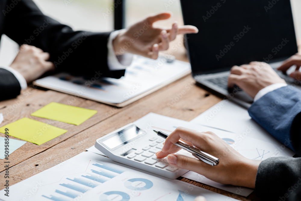 Businessman using a calculator to calculate numbers on a company's financial documents, he is analyzing historical financial data to plan how to grow the company. Financial concept. Businessman using a calculator to calculate numbers on a company's financial documents, he is analyzing historical financial data to plan how to grow the company. Financial concept.