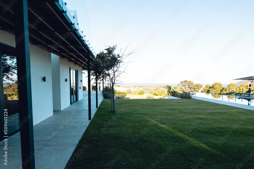 View of grassy land in yard in front of nursing home against clear sky, copy space View of grassy land in yard in front of nursing home against clear sky, copy space