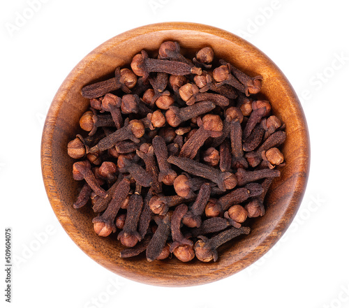 Dry cloves in wooden bowl, isolated on white background. Cloves spice. Spices and herbs. Top view.