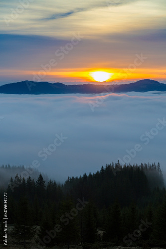 Morning orange sunbeams over misty clouds in the mountains © almostfuture