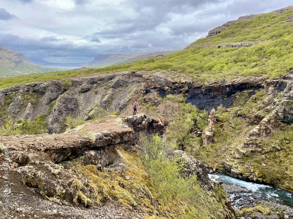 Woman looking at Glymur waterfall, second highest waterfall of Iceland.